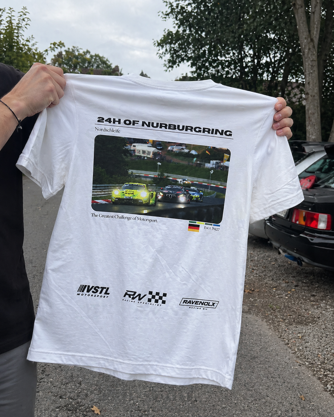 RINGWEAR 24H of Nürburgring tee held up in front of a parked car